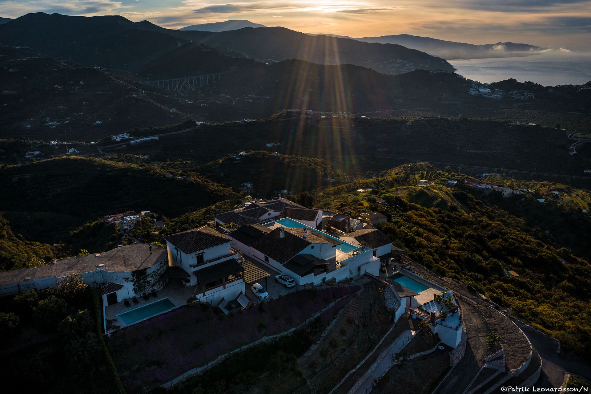 The estate from above at sunset, villas set into the hillside.