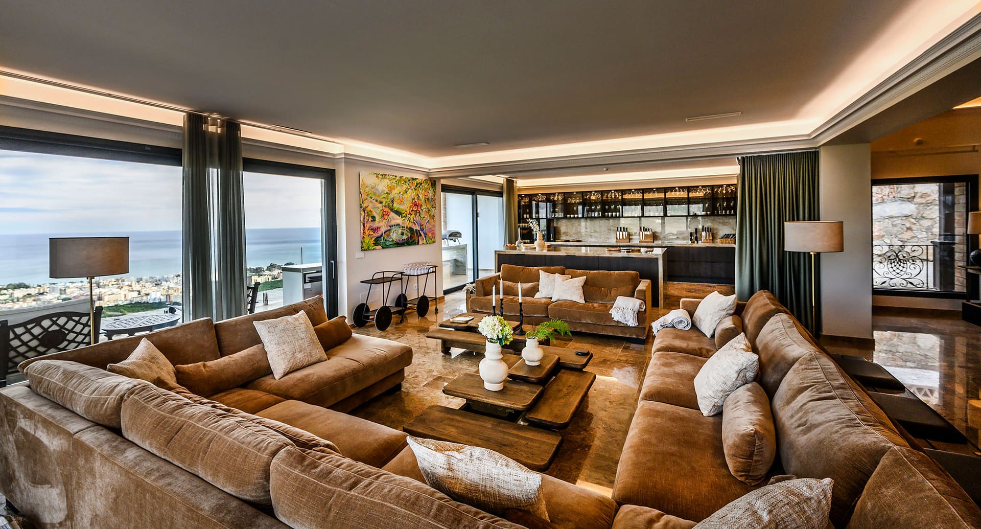 A living room open to the sea view, low light and room for a crowd.