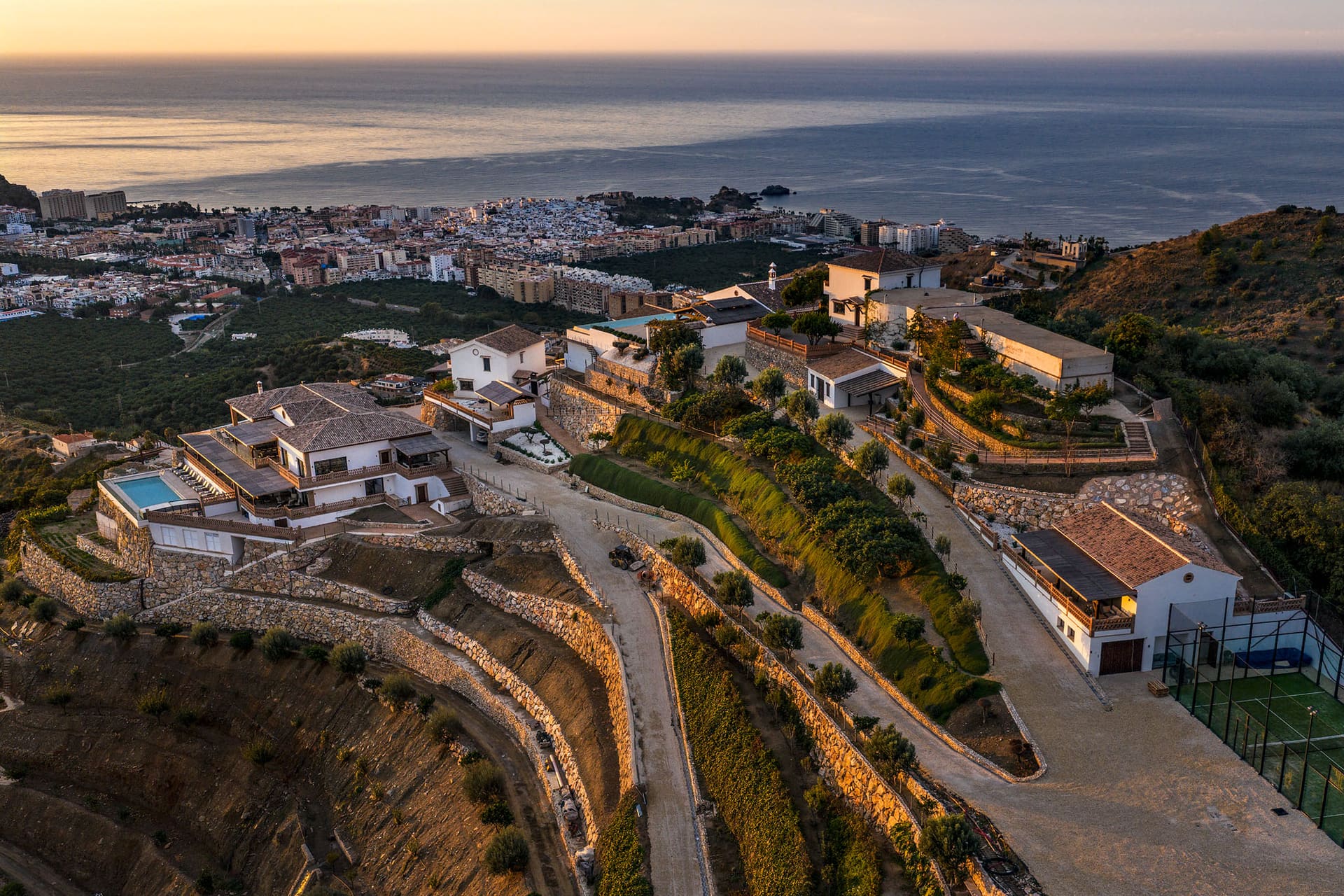The hill and its villas seen from above, Almuñécar and the coastline beyond at sunset.